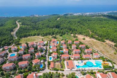 Ηλιόλουστη βίλα στην Αλάνια με ιδιωτική πισίνα, πέτρινες λεπτομέρειες και πλούσιο τροπικό τοπίο.