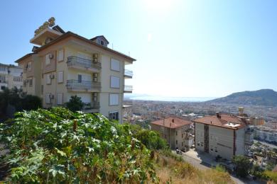Alanya kinnisvara rõdu plaatpõrandate, kaunistatud rauast reelingute ning panoraamiliste linna- ja rannikuvaadetega.
