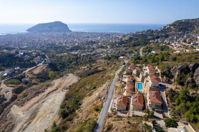 Propiedad en Alanya con una sala de estar de planta abierta con una cocina moderna, una paleta de colores neutros y cómodos asientos, creando un ambiente luminoso y aireado.