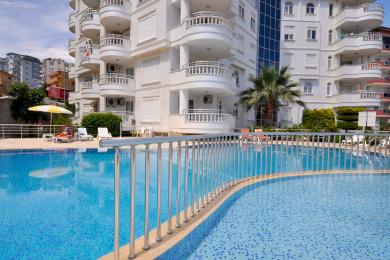 Alanya woning met balkon uitzicht op de Dim Rivier, stadsgebouwen en heldere blauwe lucht.