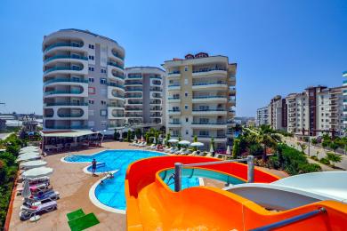Alanya eign með svölum með glerhandriði, flísalögðu gólfi og björtu, sólríku útsýni yfir borgina.