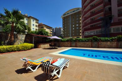 The Alanya property boasts a refreshing outdoor pool with sun loungers and a relaxing, sunny atmosphere.