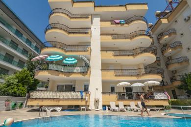 Otvorený obytný priestor apartmánu Alanya zahŕňa kuchyňu, jedálenský kút a pohodlné sedenie s prirodzeným svetlom.