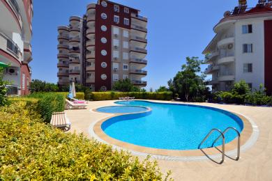 Proprietate în Alanya cu balcon cu podea de gresie, balustradă metalică și vedere panoramică asupra orașului și a munților.