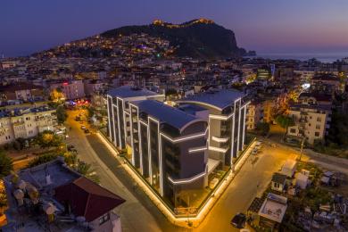 Alanya mulkidagi yashash-ovqatlanish zonasi yog'och panellari, toshli devor, zamonaviy yoritish va bog' manzaralariga ega bo'lib, iliq muhit yaratadi.