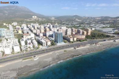 Den moderne stuen i Alanya-leiligheten har en elegant kjøkkenøy, havutsikt og stilfull pendelbelysning.