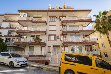 Alanya eiendom stue med luksuriøse rosa sofaer, marmorgulv og lyse, naturlige lysforhold som skaper en behagelig atmosfære.
