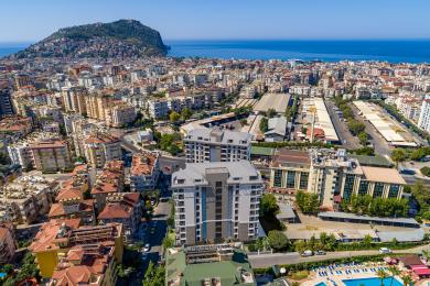 Σαλόνι ακινήτου στην Αλάνια με μοντέρνα κουζίνα, μαρμάρινες λεπτομέρειες, ζεστό φωτισμό και άνετα, κομψά έπιπλα.
