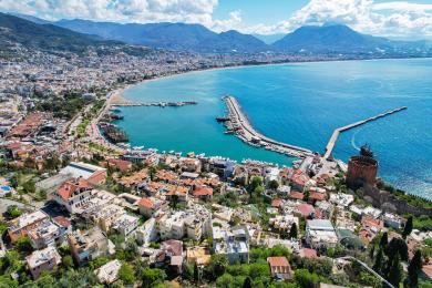 Alanya appartement balkon met wicker meubilair, blauw tafelkleed en prachtig uitzicht op de Middellandse Zee.