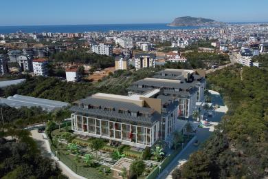 Alanya mulkidagi marmar pollari, yog'och panelli televizor devori va hashamatli muhit yaratuvchi zamonaviy halqa yoritgichlari bilan jihozlangan yashash xonasi.