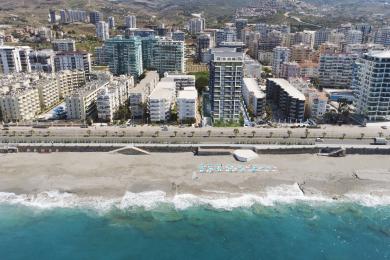 Parlaq Alanya qonaq otağı yumşaq çəhrayı divan və tavandan tavana pəncərələrdən panoramik okean mənzərələrinə malikdir.