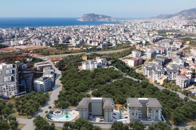 Alanya əmlakı: Zərif mətbəxi, mərmər vurğuları və parlaq atmosfer yaradan dəbli halqa işıqlandırması olan müasir açıq planlı yaşayış sahəsi.