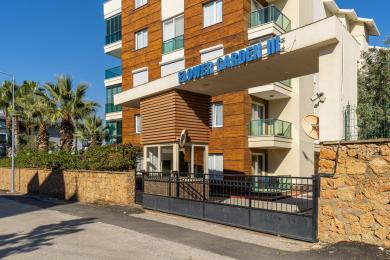 Alanya Immobilie: Helle, moderne Küche mit weißen Schränken, schwarzem Spritzschutz und Essbereich, die eine saubere, einladende Atmosphäre schafft.