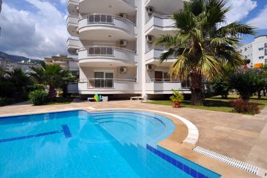 Yorqin Alanya yotoqxonasi balkon eshigi, sariq choyshablar va iliq yoritgichlar bilan xush kelibsiz muhit yaratadi.