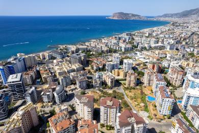 Alanya property: Bright, open-plan living area with a modern kitchen, comfortable seating, and a warm, inviting atmosphere.