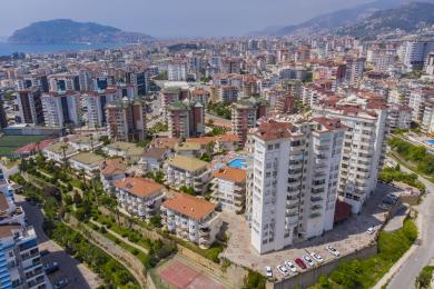 Alanya'da şehir ve deniz manzaralı, cam masa ve oturma alanına sahip balkon.