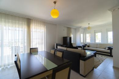 Svetla dnevna soba u Alanji sa trpezarijom, providnim zavesama, podovima od pločica i udobnim modernim nameštajem.