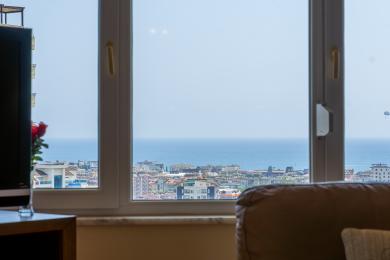 Alanya apartman nappali panorámás tengeri kilátással egy világos, modern ablakból.