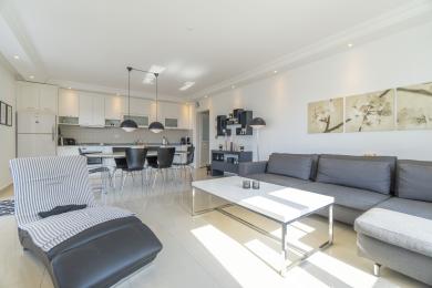 Bright, modern apartment featuring an open-concept living area with a sleek kitchen and comfortable lounge space.
