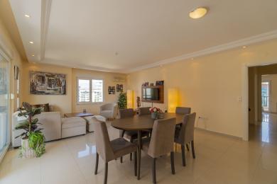 Bright, airy apartment showcases an open-plan living and dining area with modern furnishings and city views.