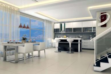 Alanya ejendom: Lyst, moderne køkken og spiseområde med havudsigt, hvide skabe og elegant, minimalistisk design.