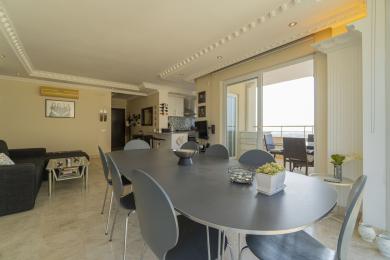 Yorug' Alanya xonadonining ochiq rejadagi yashash va ovqatlanish joyida marmar pollar va balkon bor.