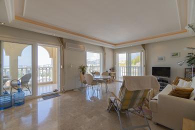 Mermer zeminli, balkon erişimli ve konforlu, modern mobilyalara sahip aydınlık Alanya oturma odası.