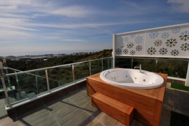 Alanya-Immobilienbalkon mit einem holzverkleideten Whirlpool mit malerischer Aussicht und dekorativem Schneeflocken-Sichtschutz.