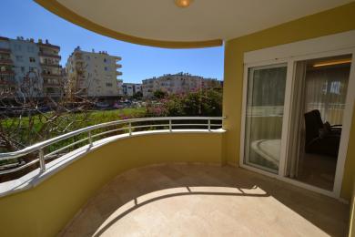 Alanya property balcony with tile flooring, metal railing, and bright, sunny views of the neighborhood.