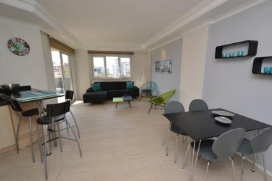 De woonkamer van dit pand in Alanya beschikt over een moderne eethoek, comfortabele zitplaatsen en helder, natuurlijk licht.