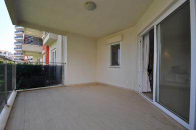 Balkon nekretnine u Alanji sa podovima od pločica, staklenom ogradom i svijetlom, prozračnom atmosferom.