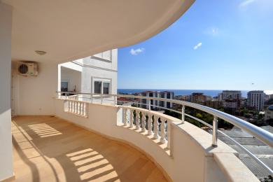 Lys og romslig balkong i Alanya med fliser, hvit balustrade og fantastisk utsikt over Middelhavet.