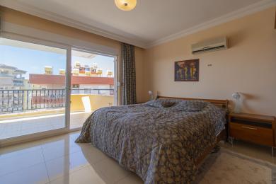 Bright bedroom in a Mediterranean apartment with balcony access and sunny city views.
