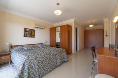 Spacious bedroom in this Mediterranean villa features ample closet space and a bright, airy atmosphere.
