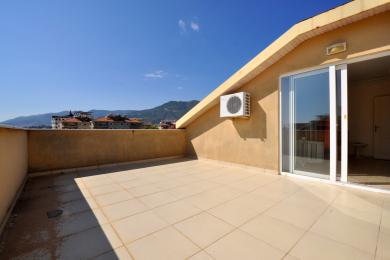 Alanya mulkidagi plitka polli, gipsli devorli, surma oynali eshikli va tog 'manzarali balkon.