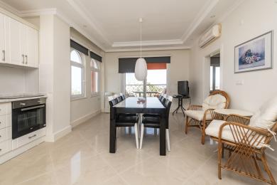 Yorqin Alanya ovqatlanish joyi kafel pollari, zamonaviy qora stol, tol stullar va balkon chiqish joyiga ega.