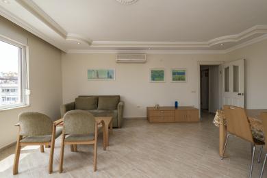 Alanya fastighet vardagsrum med klinkergolv, neutral inredning, bekväma sittplatser och starkt naturligt ljus.