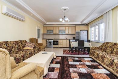 Alanya appartement woonkamer beschikt over een gecombineerde keuken, tegelvloeren en comfortabele zitplaatsen met natuurlijk licht.