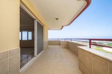 Prostrani balkon u Alanji s podovima od pločica, mramornim detaljima i zadivljujućim pogledom na more pod vedrim, sunčanim nebom.