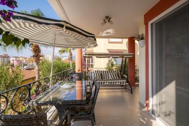 Alanya mulkidagi rattan mebellari, chiziqli arg'imchoq va shahar manzaralari bilan jihozlangan balkon, dam olish uchun ochiq havoda yashash joyini yaratadi.