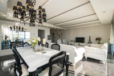 Propriedade em Alanya: Elegante área de estar e jantar com pisos de mármore, móveis brancos e um lustre impressionante.