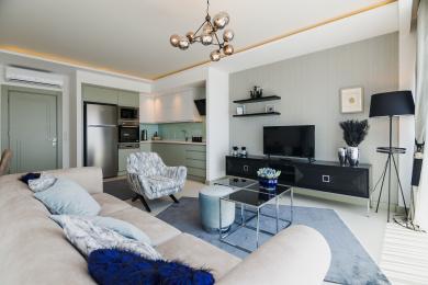 Salón de propiedad en Alanya con iluminación moderna, cocina elegante, sofá cómodo y decoración elegante que crea un ambiente relajante.