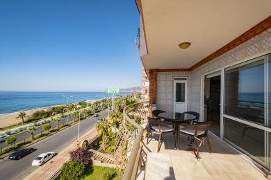 Balkon apartmana u Alanji s pogledom na more, s blagovaonicom i ukrasnim pločicama, okupan jarkim suncem.
