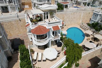 Alanya villa eksteriør viser et privat basseng, solsenger og flere terrasser med arkitektur i middelhavsstil.