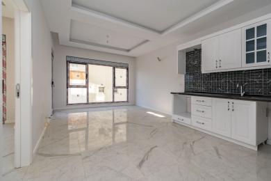 Beyaz dolapları, siyah backsplash'i, mermer zeminleri ve büyük pencereleri olan aydınlık Alanya apartman mutfağı.