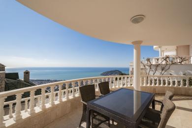 Balkon nekretnine u Alanji s mramornim podovima, bijelom balustradom i zadivljujućim pogledom na Sredozemno more.