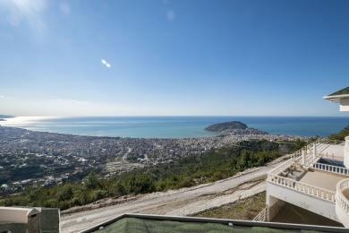Alanya eign með svölum með töfrandi víðsýni yfir borgina og Miðjarðarhafið, baðað í björtu sólarljósi.