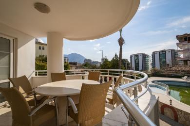 Günəşli Alanya eyvanı, hörük stullar, mərmər məhəccər və dağ mənzərələri ilə rahat bir açıq yaşayış sahəsi yaradır.