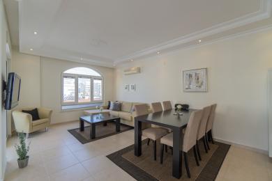 Proprietate în Alanya, living cu un set de dining modern, canapea confortabilă și decor luminos, neutru.