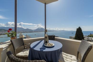 Alanya appartement balkon met wicker meubilair, blauw tafelkleed en prachtig uitzicht op de Middellandse Zee.